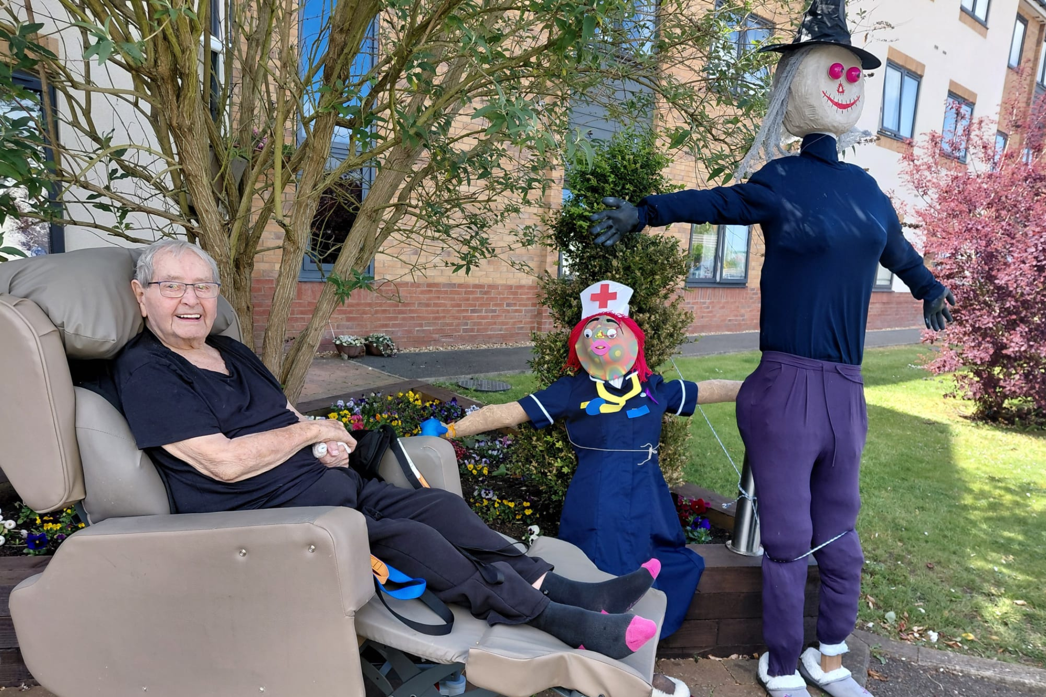 Resident and scarecrow in carte home gardens